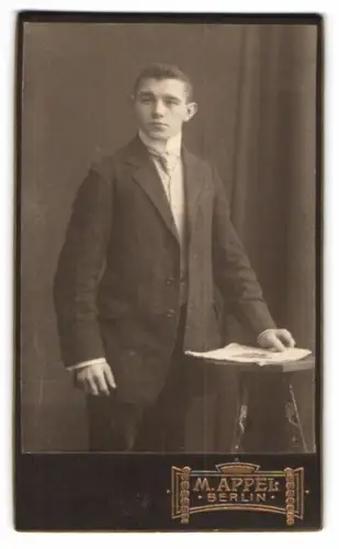 Fotografie M. Appel, Berlin, Neue Königstr. 1, Porträt eines jungen Mannes mit Tisch
