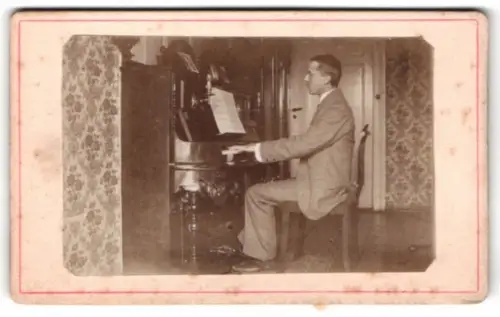 Fotografie Mann spielt Kalvier in seinem Wohnzimmer