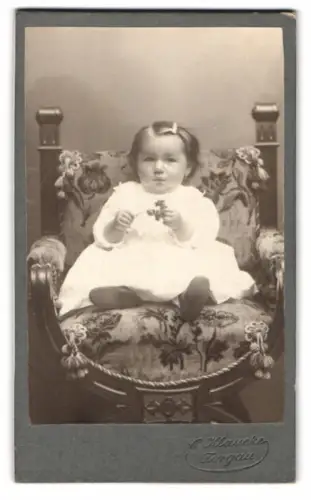 Fotografie E. Klaucke, Torgau, kleines Kind auf einem kunstvollen Sessel