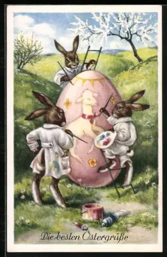 Künstler-AK Drei Osterhasen bemalen ein Osterei, Herzliche Ostergrüsse