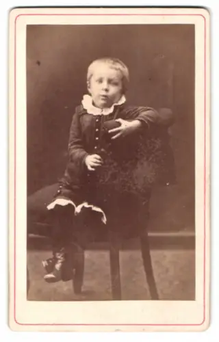 Fotografie unbekannter Fotograf und Ort, Gunnar auf einem Stuhl sitzend