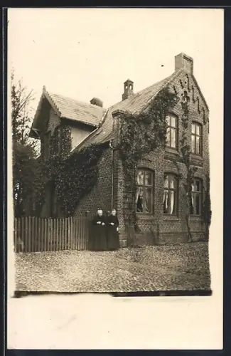 AK Husum / Nordsee, Zwei Frauen vor einem Haus