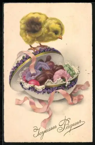 Künstler-AK Osterküken blickt auf ein mit Süssigkeiten gefülltes Osterei, Joyeuses Paques