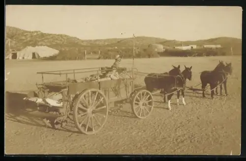 Foto-AK Soldat transportiert verwundeten Kamerad im Eselwagen, Zelt, Berge