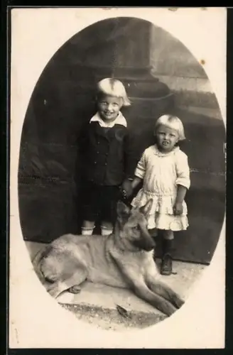 Foto-AK Zwei blonde Kinder mit liegendem Schäferhund