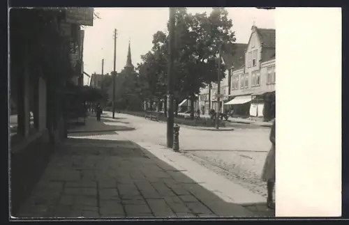 Foto-AK Bad Pyrmont, Strassenansicht, Geschäfte, Kirche im Hintergrund