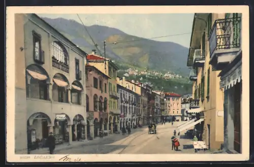 AK Locarno, Strassenpartie mit Geschäften und Bergpanorama