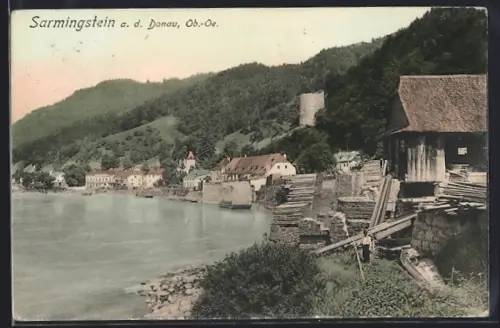 AK Sarmingstein a. d. Donau, Donaupartie mit Uferpanorama, Holzlager und Wehrturm