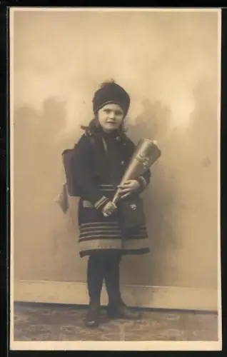 Foto-AK Kleines Mädchen in einem Mantel und Mütze mit ihrer Schultüte