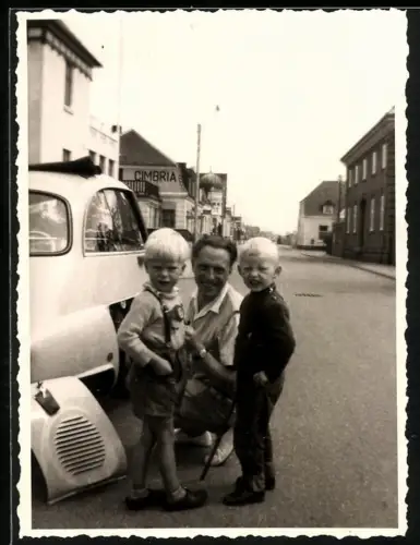 Fotografie Auto, stolzer Vater mit seinen blonden Söhnen beim Radwechsel