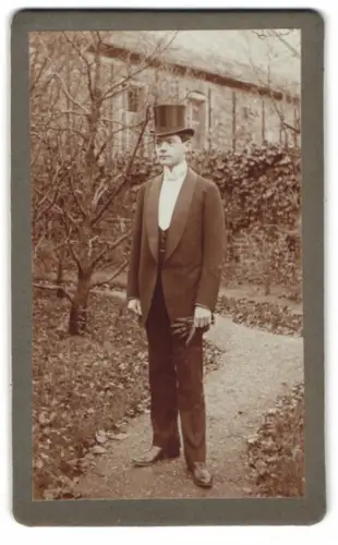 Fotografie Alfred Frölich, Offenbach a. M., Domstrasse 16, Eleganter Herr mit Zylinder im Garten 1911