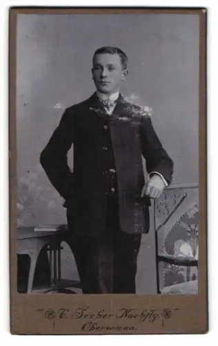 Fotografie C. Seeber Nachf., Oberwiesa, Eleganter junger Mann mit Stuhl