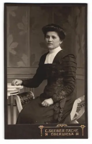 Fotografie C. Seeber Nachf., Oberwiesa, Frau in schwarzem Kleid sitzt an einem Tisch
