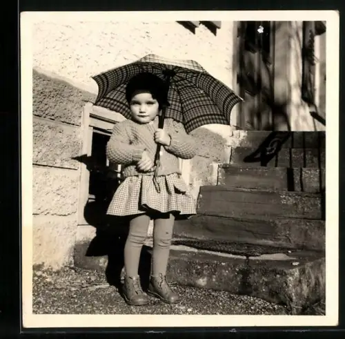 Fotografie Mädchen mit Regenschirmm trägt Kleid und Pullover zu Weihnachten 1959