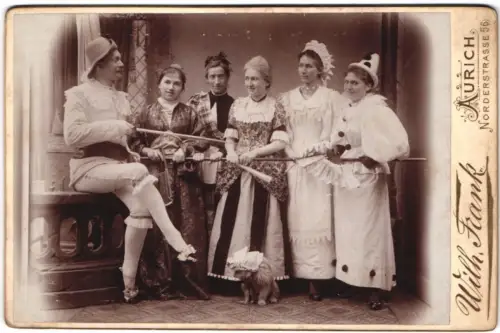 Fotografie Wilh. Frank, Aurich, Herr Gravenhorst im Kostüm hallt Frauen in Kostümen bei der Stange, Fasching