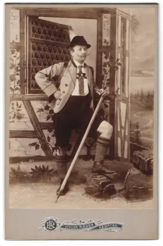 Fotografie R. Eder, Kempten, junger Mann als Wandere in Lederhose mit Wanderpickel vor einer Studiokulisse