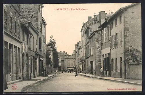 AK L`Arbresle, Rue de Bordeaux animée avec des passants et bâtiments anciens