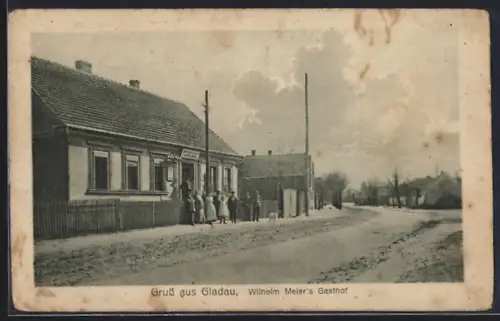 AK Gladau, Gasthof Wilhelm Meier mit Strasse und kleiner Versammlung