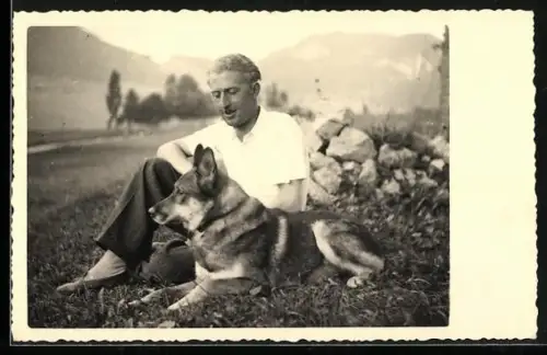 Foto-AK Herrchen und Schäferhund auf einer Wiese, Bergpanorama
