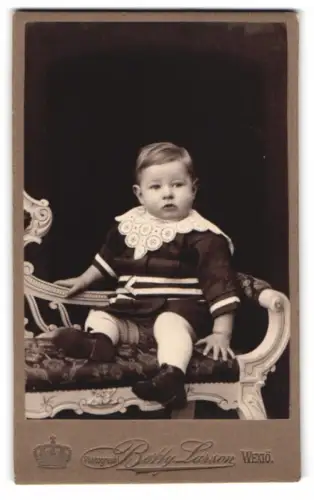 Fotografie Betty Larson, Wexiö, Kleinkind auf einem kunstvollen Stuhl
