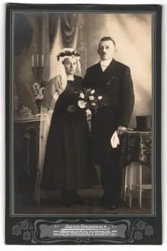 Fotografie Julius Grunewald, Oberneukirch, Brautpaar im schwarzen Hochzeitskleid und Anzug nebst Zylinder