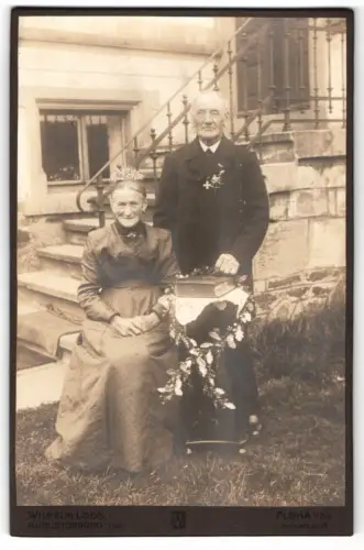 Fotografie Wilhelm Loos, Augustusburg, Bismarckstr. 26, Älteres Paar auf Treppe am Hochzeitstag, Mann mit Orden