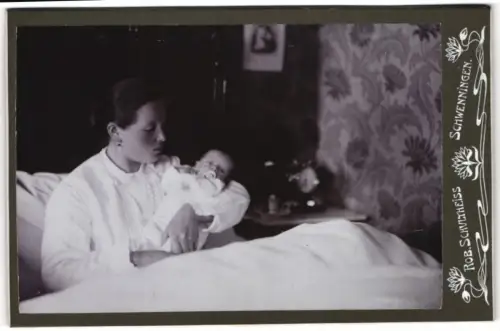 Fotografie Robert Schultheiss, Schwenningen, Mutter mit Baby in einem gemütlichen Zimmer, Mutterglück