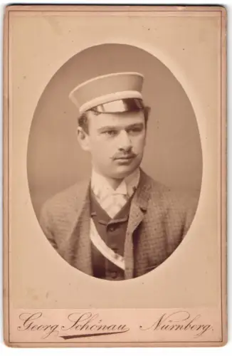 Fotografie Georg Schönau, Nürnberg, Student im karierten Anzug mit Scherpe und Tellermütze