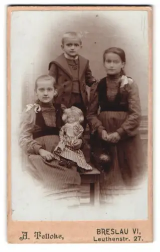 Fotografie A. Telloke, Breslau, Leuthenstr. 27, Drei Kinder mit grosser Puppe auf dem Schoss