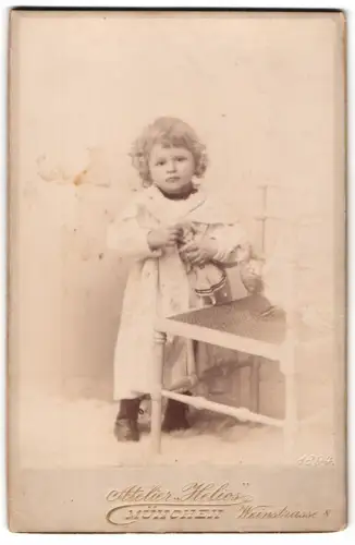Fotografie Atelier Helios, München, Weinstrasse 8, Kleinkind mit Puppe und Taube auf dem Stuhl