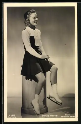 AK Schlittschuhläuferin Sonja Henie auf einem Sockel sitzend