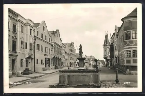 AK Neufelden /O.-Ö., Strassenpartie mit Brunnen und Turm