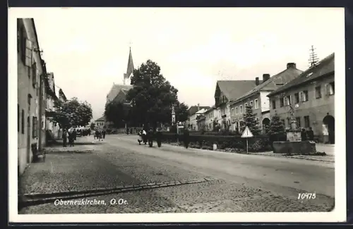 AK Oberneukirchen /O.-Ö., Strassenpartie mit Brunnen, Anlage, Säulendenkmal u. Kirche