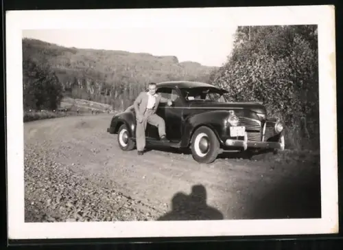 Fotografie Auto Plymouth Deluxe, Bursche posiert lässig am PKW
