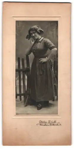 Fotografie Atelier Düll, München, Türkenstrasse 31, Frau in traditioneller Kleidung an einem Holzzaun