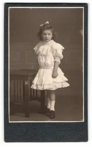 Fotografie H. Schmeck, Siegen, Bahnhofstrasse 12, Mädchen im weissen Kleid neben Tisch