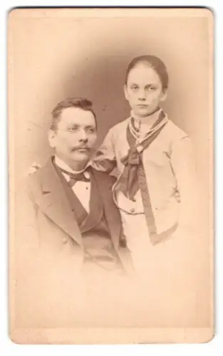 Fotografie J. Bleibel, Stuttgart, Im römischen Kaiser, Porträt eines Mannes mit Kind