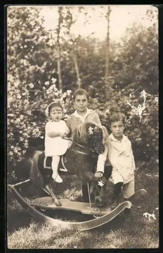 Foto-AK Ernst Fischer und zwei weitere Kinder mit einem Schaukelpferd