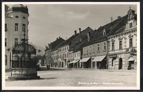 AK Bruck a. d. Mur, Bismarckstrasse mit Geschäften u. Eisernem Brunnen