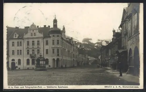 AK Bruck a. d. Mur, K. k. Postamt und Städtische Sparkasse mit Bismarckstrasse, Gasthaus, Eiserner Brunnen