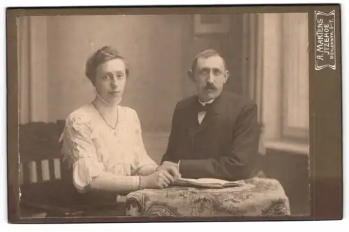 Fotografie Ad. Martens, Itzehoe, Mühlenstrasse 5-7, Paar am Tisch mit Buch