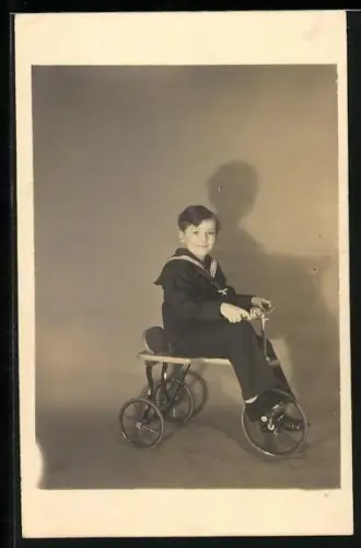 Foto-AK Junge in Matrosen-Anzug auf einem Fahrrad