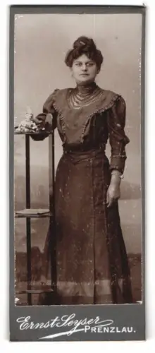 Fotografie Ernst Leyser, Prenzlau, Dame in elegantem Kleid mit Blumenarrangement