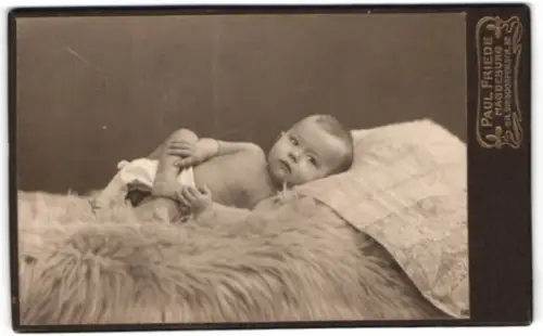 Fotografie Paul Friede, Magdeburg, Gr. Diesdorferstr. 32, Kind auf Fell liegend