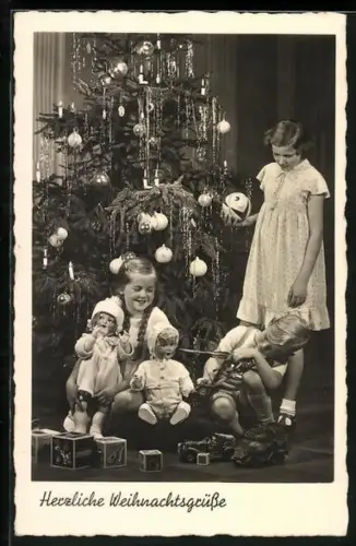 AK Kinder freuen sich über Puppen zu Weihnachtenm Knabe mit Spilzeug Flak und Panzerwagen