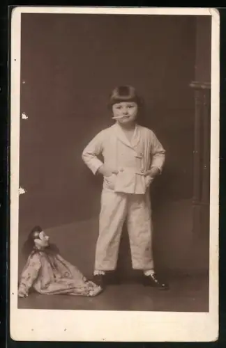 AK kleines Mädchen im Pyjama mit Zigarette im Mund nebst Kasperle Puppe auf dem Boden