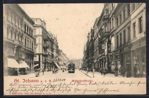 AK St. Johann a. d. S., Bahnhofstrasse mit Strassenbahn und Geschäften