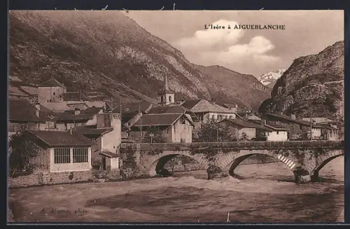 AK Aigueblanche, L`Isère traversant le village avec son pont pittoresque et montagnes en arrière-plan