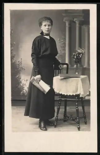 Foto-AK Dame neben einem Tisch mit Blumenvase