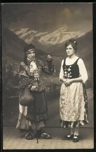 Foto-AK Zwei Personen in traditioneller Kleidung vor einer Bergkulisse